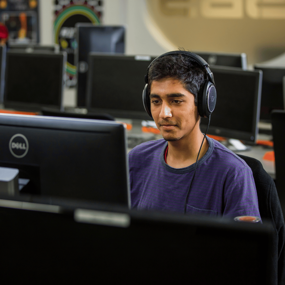 image of student on the computer with headphones 