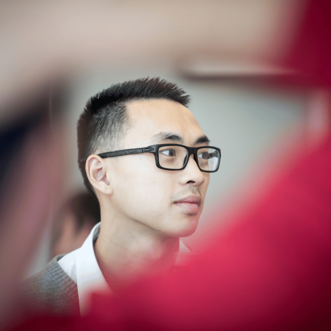student with glasses looking away