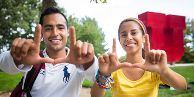 two students flashing the "u" hand sign